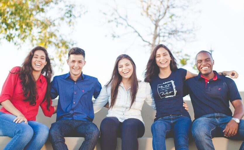 group of people sitting on bench near trees duting daytime